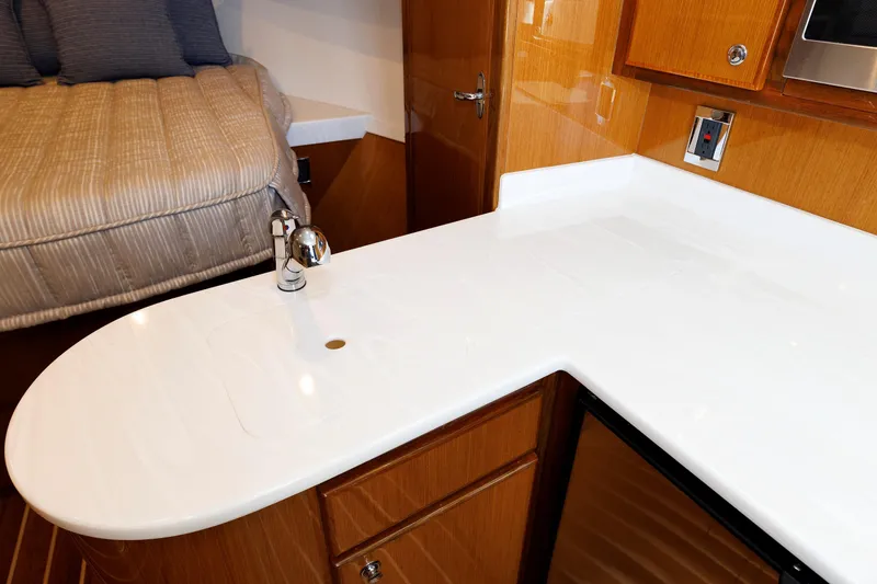 Slide: The Image of 2023 Henriques 42 Express Hardtop interior with sleek kitchenette and cozy sleeping area. - 48