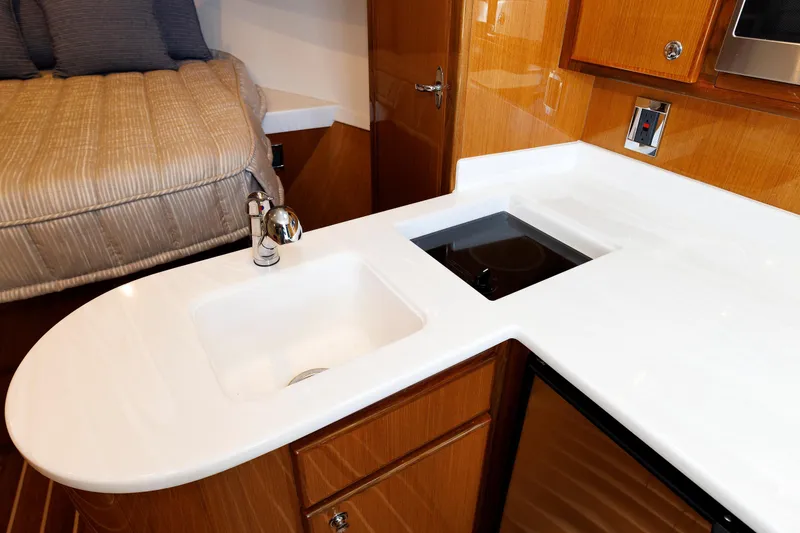 Slide: The Image of 2023 Henriques 42 Express Hardtop interior with modern kitchen and cozy sleeping area. - 49