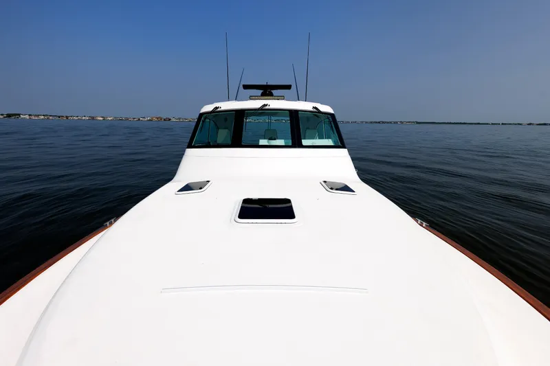 Slide: The Image of 2023 Henriques 42 Express Hardtop boat on calm water, clear sky background. - 56
