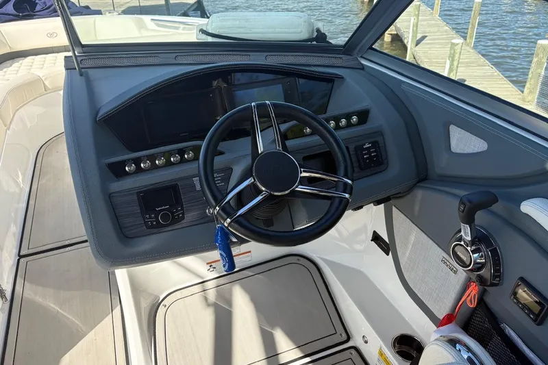 Slide: The Image of 2019 Cobalt R5 boat dashboard with steering wheel and control panel by the water. - 18
