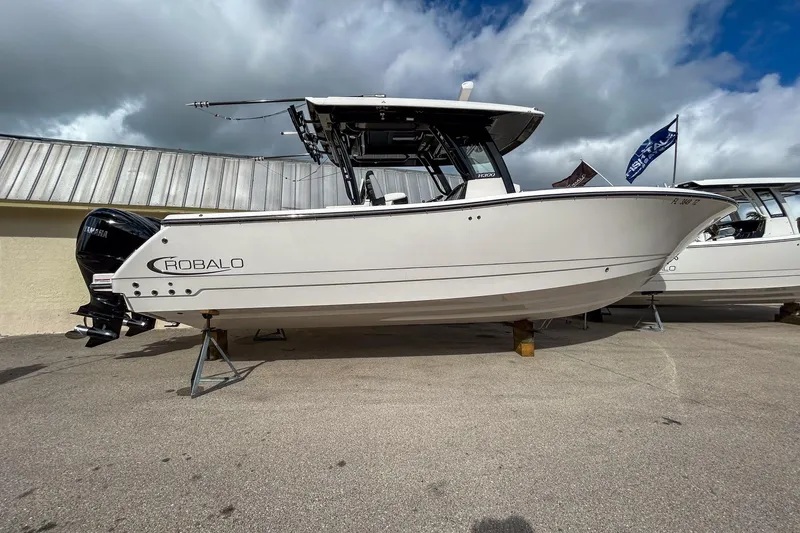 The Image of 2025 Robalo R300 Center Console boat displayed outdoors on stands. - 0