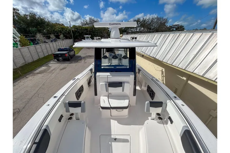 Slide: The Image of 2025 Robalo R300 Center Console boat with Garmin equipment, docked outdoors under a blue sky. - 11