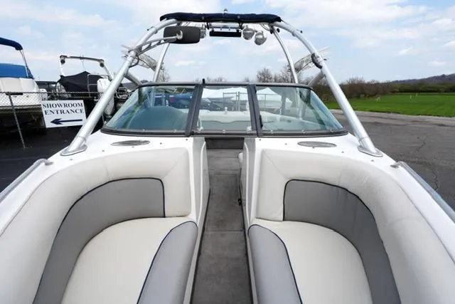 Slide: The Image of 2006 Supra Launch 20 SSV boat interior with white and gray seating, docked outdoors. - 10