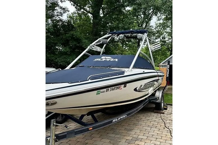 Slide: The Image of 2006 Supra Launch 20 SSV boat on trailer, covered and parked on brick driveway. - 3