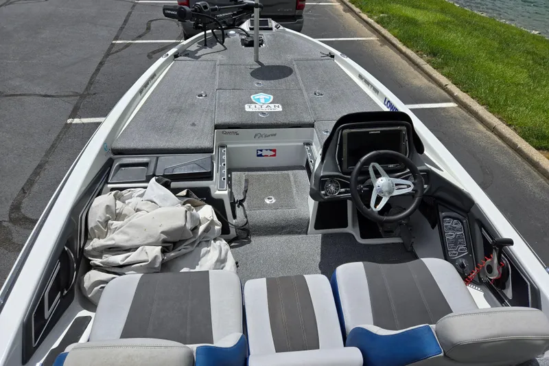 Slide: The Image of 2015 Skeeter FX20 boat interior with steering wheel and seating in a parking lot. - 12