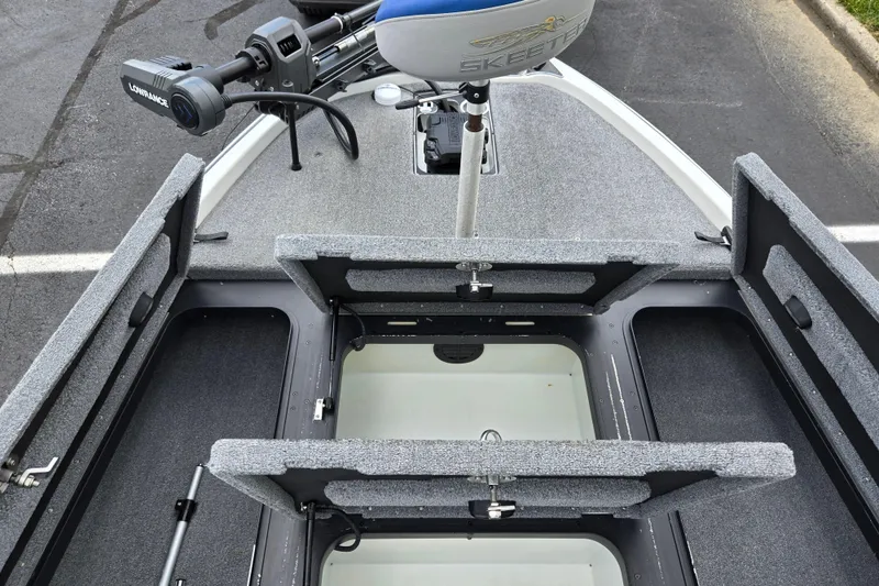 Slide: The Image of 2015 Skeeter FX20 boat interior with open storage compartments and trolling motor. - 16