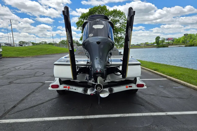 Slide: The Image of 2015 Skeeter FX20 boat on trailer by a lake under a cloudy sky. - 2