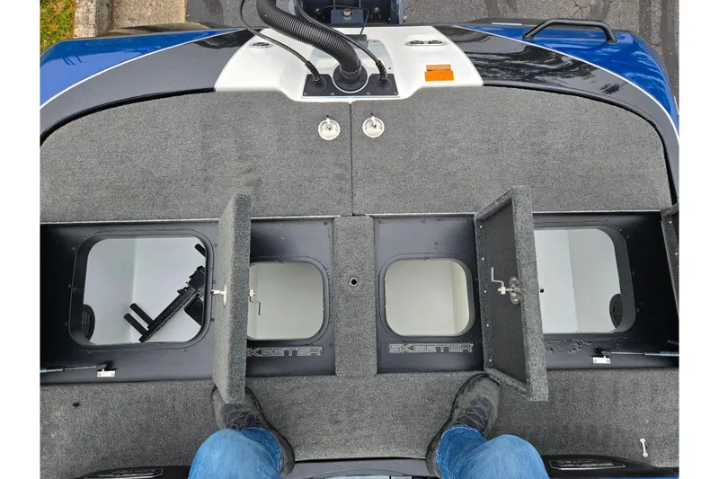 Slide: The Image of 2021 Skeeter FXR20 boat deck with open storage compartments and gray carpeting. - 14
