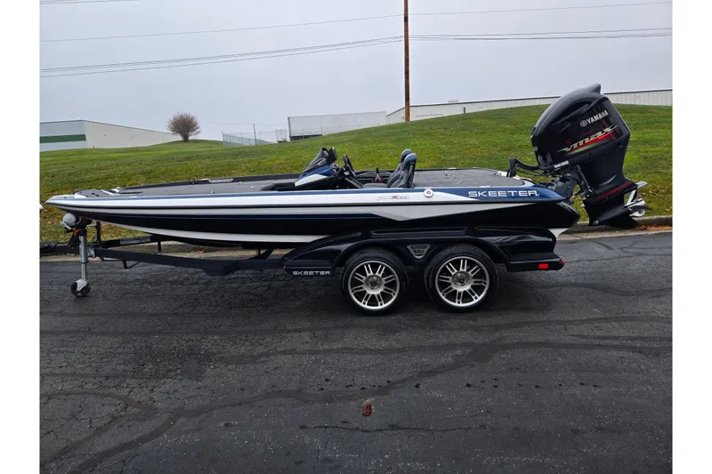 Slide: The Image of 2021 Skeeter FXR20 boat with Yamaha engine on a trailer, parked outdoors. - 4