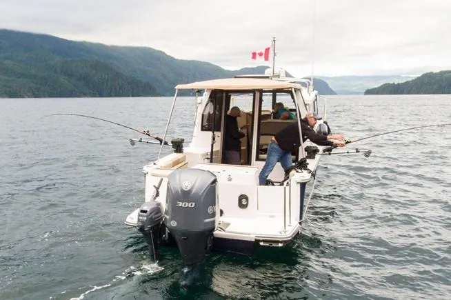 Slide: The Image of Manufacturer Provided Image: 2025 Ranger Tugs R-27 fishing boat on scenic lake with Canadian flag. - 6