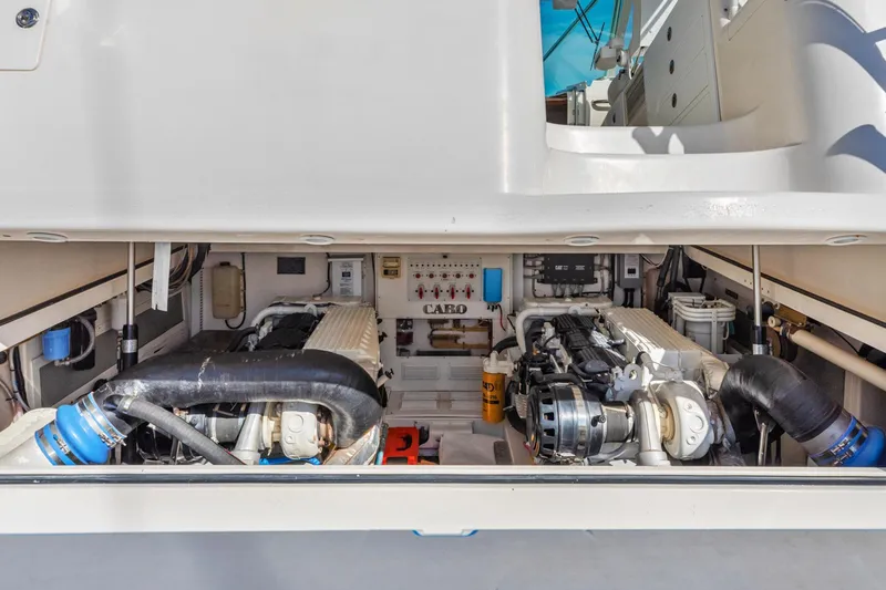 Slide: The Image of Engine compartment of 2004 Cabo 40 Express boat, showcasing dual engines and mechanical components. - 12