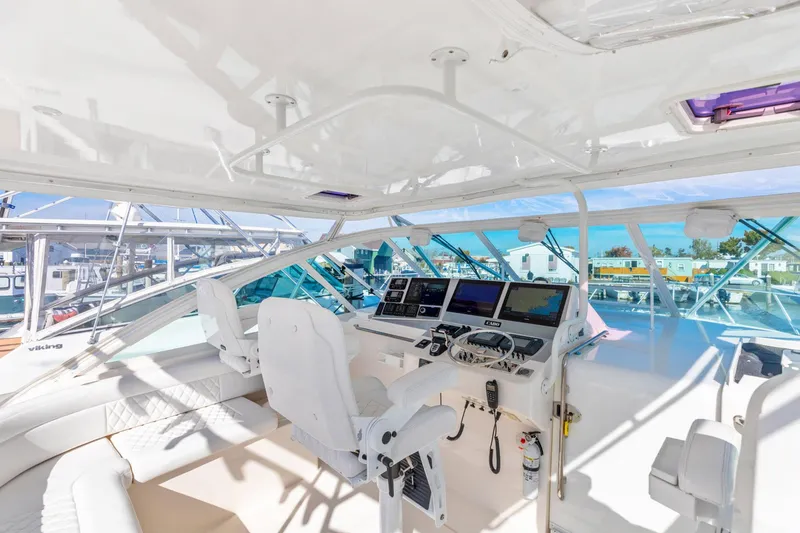 Slide: The Image of 2004 Cabo 40 Express yacht cockpit with modern navigation equipment and white seating. - 13