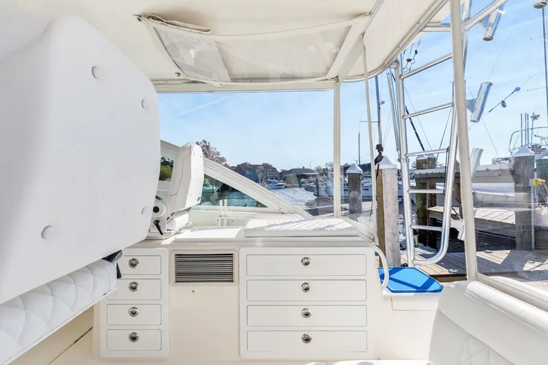 Slide: The Image of 2004 Cabo 40 Express yacht interior with white cabinetry and marina view. - 17