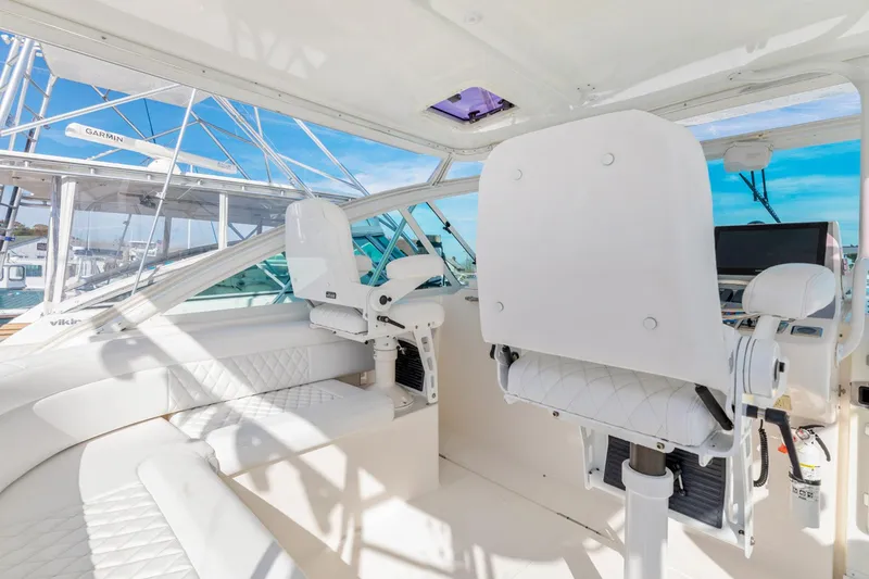 Slide: The Image of Interior of 2004 Cabo 40 Express yacht with white seating and helm station. - 19