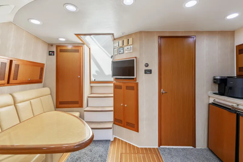 Slide: The Image of 2004 Cabo 40 Express interior with beige seating, wooden accents, and modern amenities. - 21