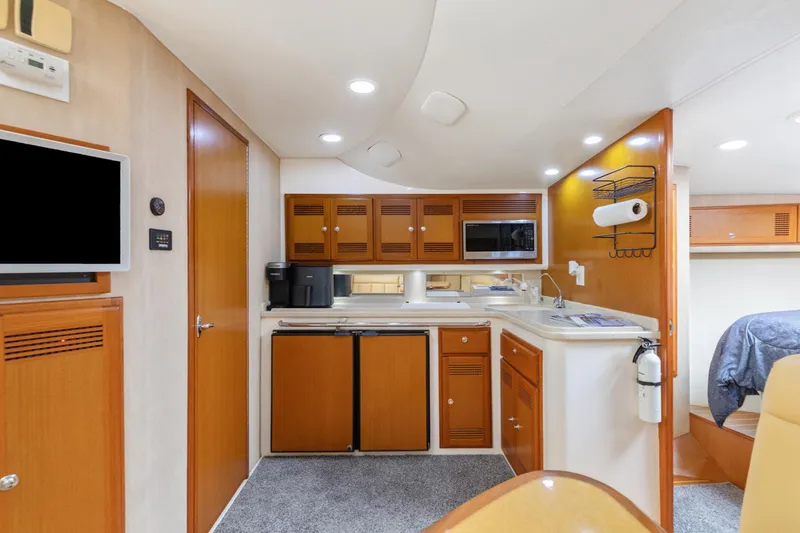 Slide: The Image of Interior of 2004 Cabo 40 Express yacht with kitchen and seating area. - 22