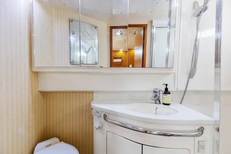 Slide: The Image of Bathroom interior of 2004 Cabo 40 Express yacht, featuring sink, mirror, and shower. - 28