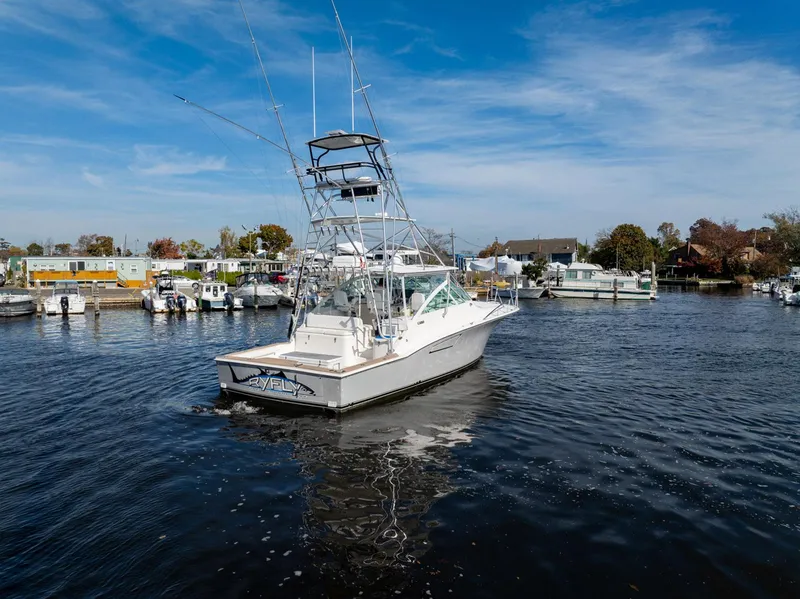 Slide: The Image of 2004 Cabo 40 Express boat cruising in a marina under a clear blue sky. - 3