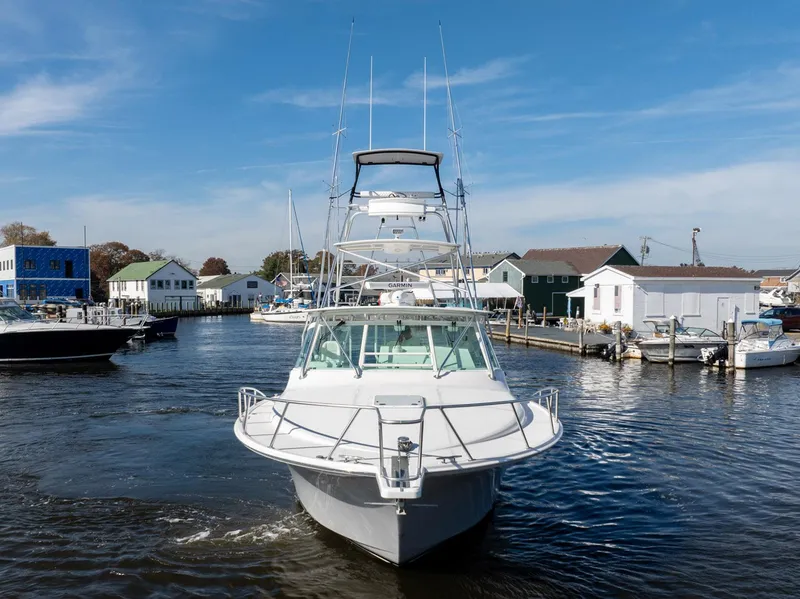 Slide: The Image of 2004 Cabo 40 Express boat docked in a marina, clear sky background. - 4