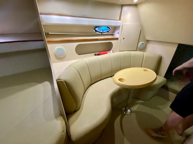 Slide: The Image of 1999 Cruisers Yachts 2870 Express interior with beige seating and table. - 10