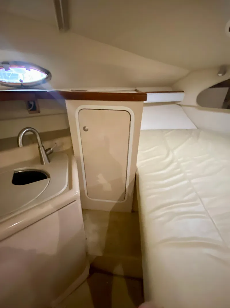 Slide: The Image of 1999 Cruisers Yachts 2870 Express cabin interior with sink, storage, and bed. - 13