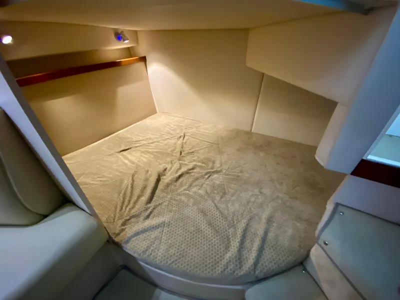 Slide: The Image of 1999 Cruisers Yachts 2870 Express cabin interior with cozy bed and soft lighting. - 14