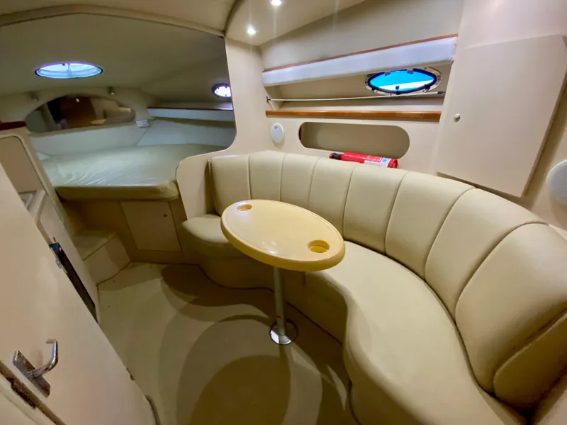 Slide: The Image of 1999 Cruisers Yachts 2870 Express interior with beige seating and table. - 15