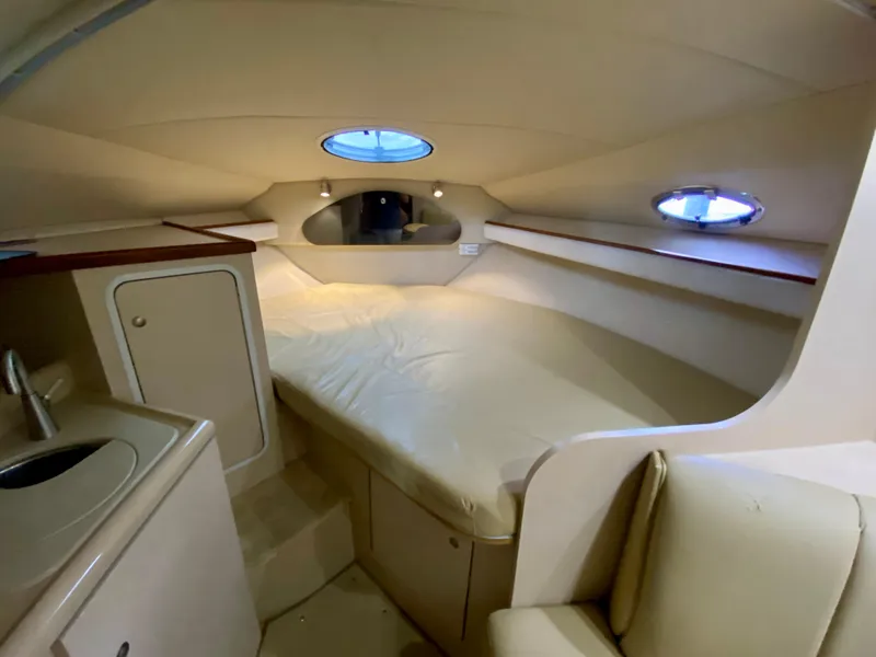 Slide: The Image of 1999 Cruisers Yachts 2870 Express cabin interior with bed, sink, and storage. - 16