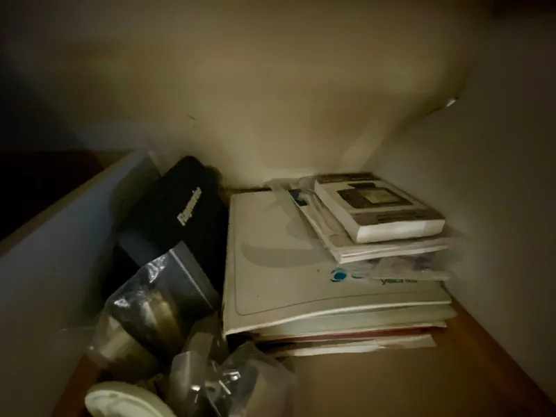 Slide: The Image of Storage compartment with manuals and items on a 1999 Cruisers Yachts 2870 Express. - 17