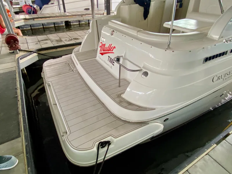 Slide: The Image of 1999 Cruisers Yachts 2870 Express docked, showcasing rear deck and branding. - 23
