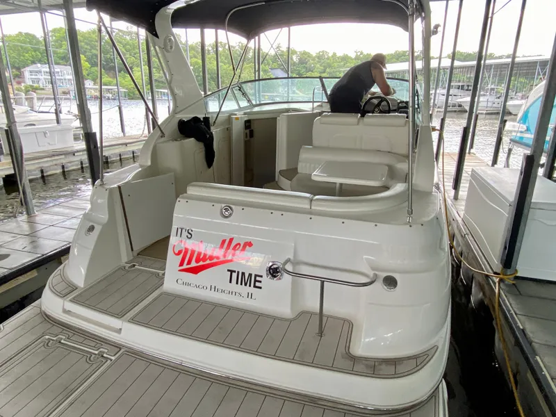 Slide: The Image of 1999 Cruisers Yachts 2870 Express docked, featuring spacious deck and seating area. - 24