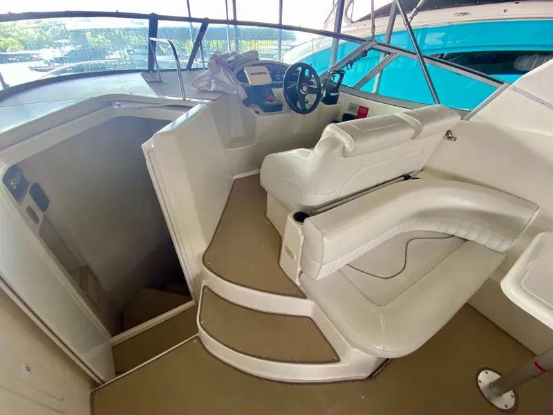 Slide: The Image of 1999 Cruisers Yachts 2870 Express helm with white seating and cabin entrance. - 5