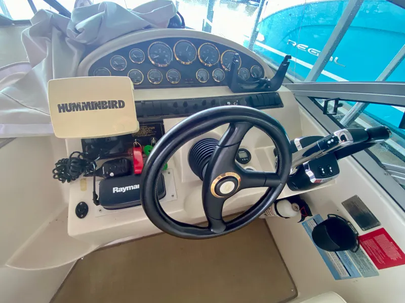 Slide: The Image of 1999 Cruisers Yachts 2870 Express helm with steering wheel, gauges, and navigation equipment. - 8