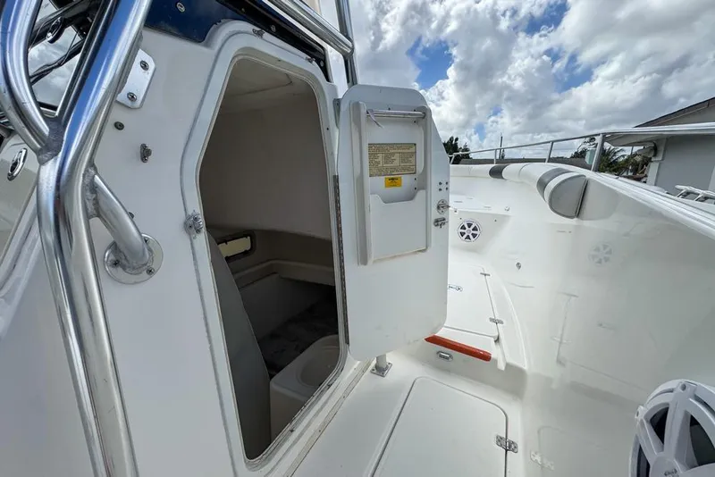 Slide: The Image of 2000 Century 3200 Center Console boat interior with open cabin door under cloudy sky. - 110