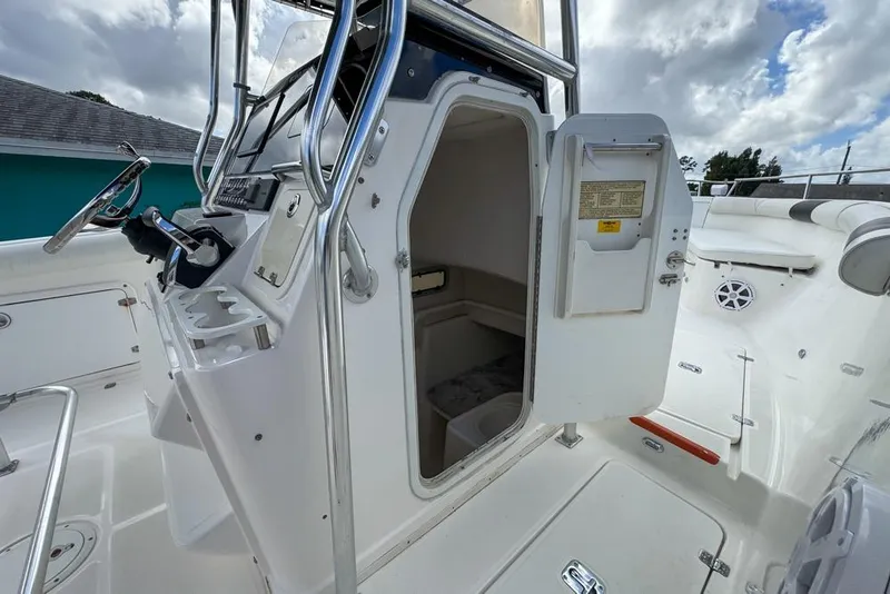 Slide: The Image of 2000 Century 3200 Center Console boat interior with open cabin door and steering console. - 111