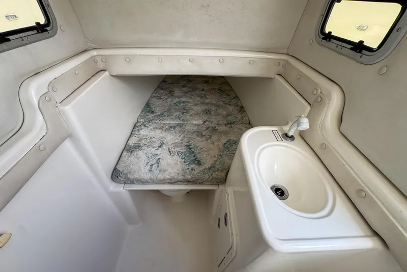 Slide: The Image of 2000 Century 3200 Center Console cabin interior with sink and cushioned seating. - 113