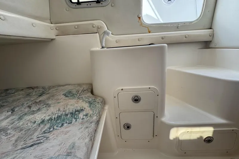 Slide: The Image of Interior of a 2000 Century 3200 Center Console boat, featuring seating and storage compartments. - 115