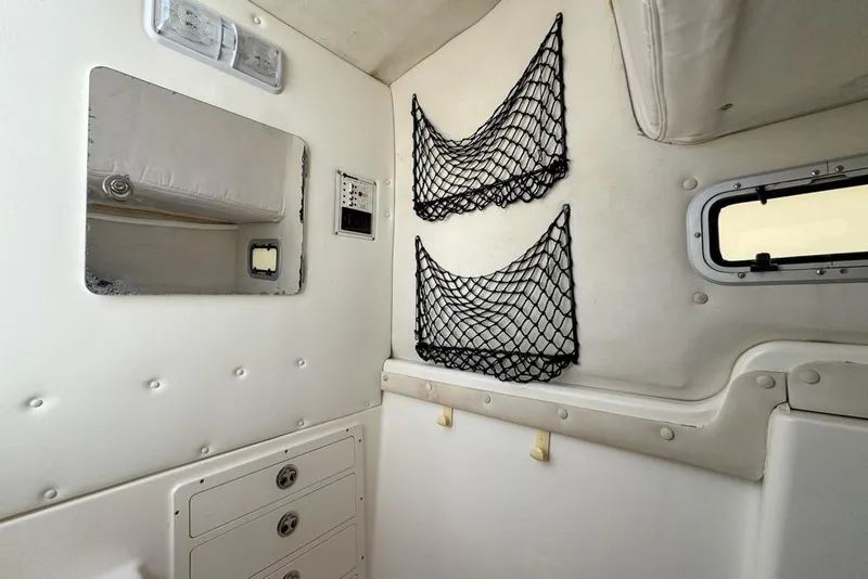 Slide: The Image of Interior of a 2000 Century 3200 Center Console boat with storage nets and compartments. - 119