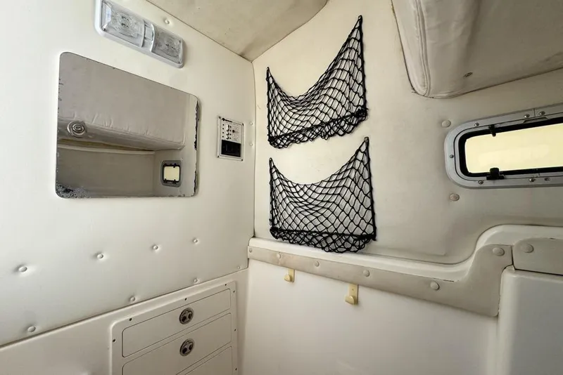 Slide: The Image of Interior of a 2000 Century 3200 Center Console boat with storage nets and window. - 120