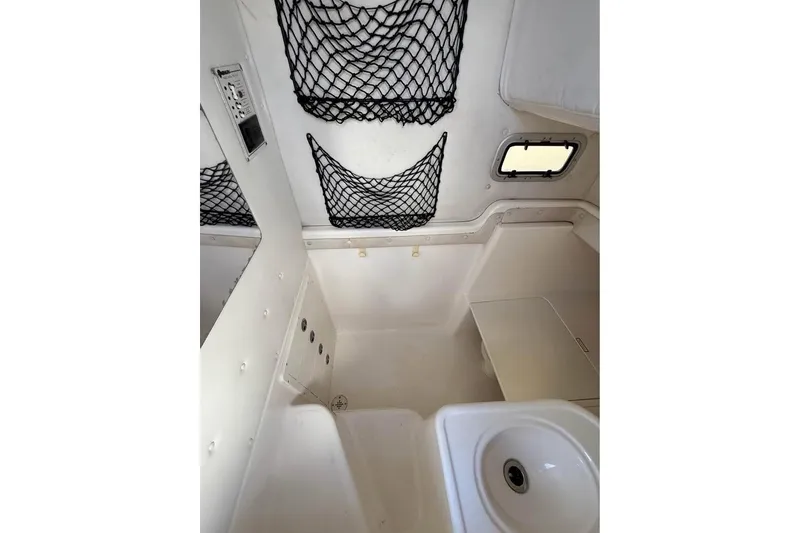 Slide: The Image of Century 3200 Center Console boat on trailer beside house, under blue sky. - 17