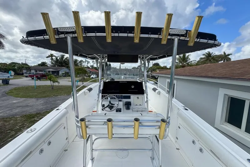 Slide: The Image of Century 3200 Center Console boat, 2000 model, with T-top and rod holders, parked outdoors. - 23