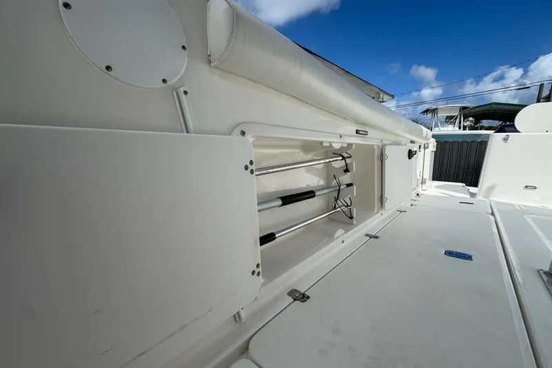 Slide: The Image of 2000 Century 3200 Center Console boat with open storage compartment under clear blue sky. - 40