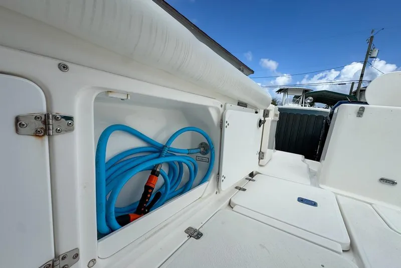Slide: The Image of Storage compartment on a 2000 Century 3200 Center Console boat with blue hose. - 42