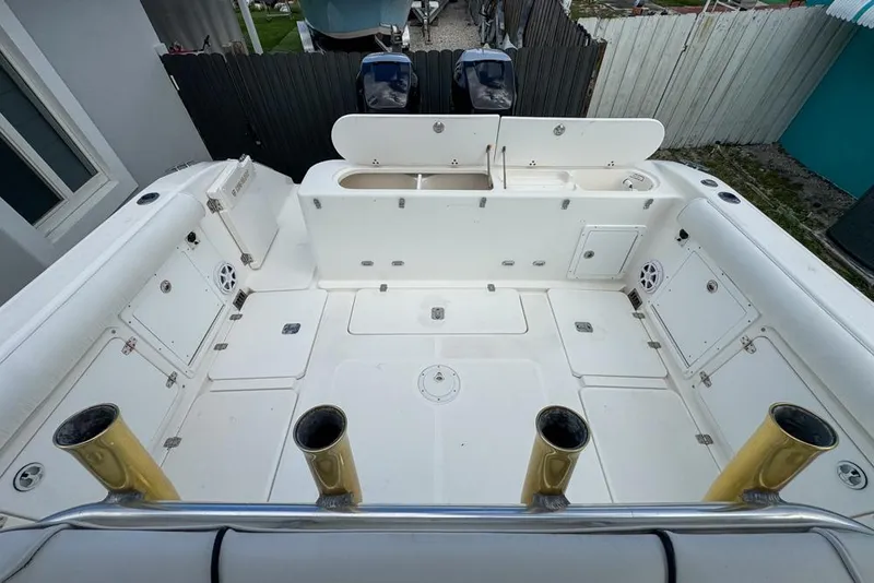 Slide: The Image of 2000 Century 3200 Center Console boat deck with storage compartments and rod holders. - 49