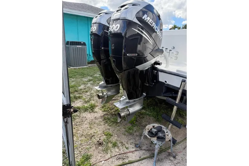 Slide: The Image of 2000 Century 3200 Center Console boat on trailer, parked beside a house. - 5