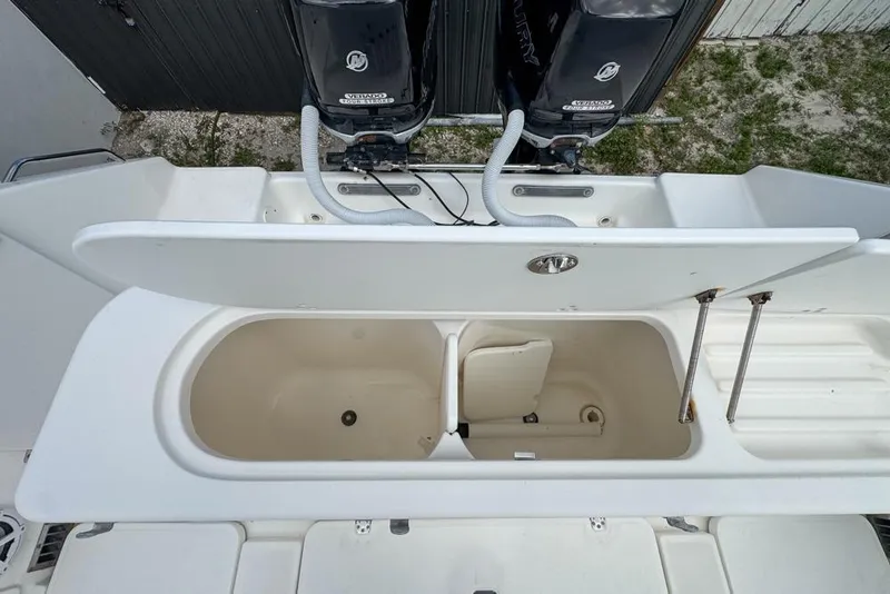 Slide: The Image of Open storage compartment on a 2000 Century 3200 Center Console boat with dual Mercury engines. - 52