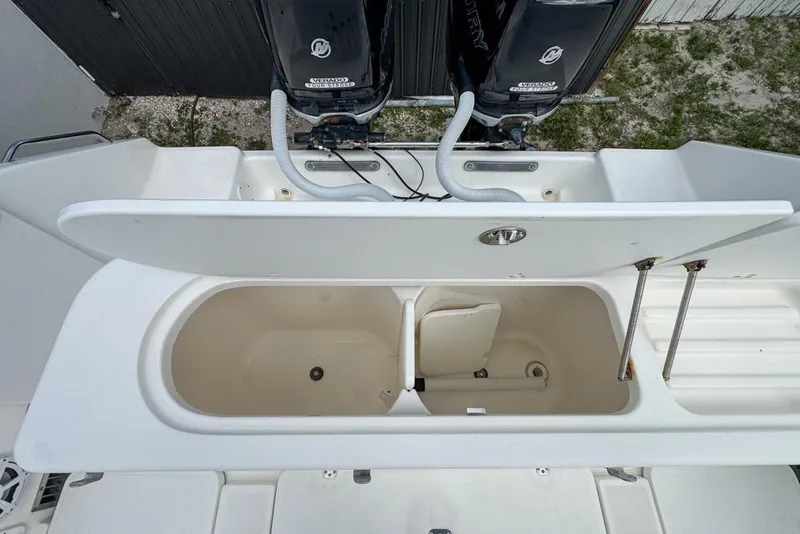 Slide: The Image of Open storage compartment on a 2000 Century 3200 Center Console boat, with dual outboard motors. - 53