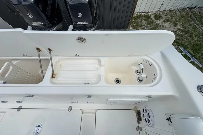 Slide: The Image of 2000 Century 3200 Center Console boat with open storage compartments and dual Mercury engines. - 54