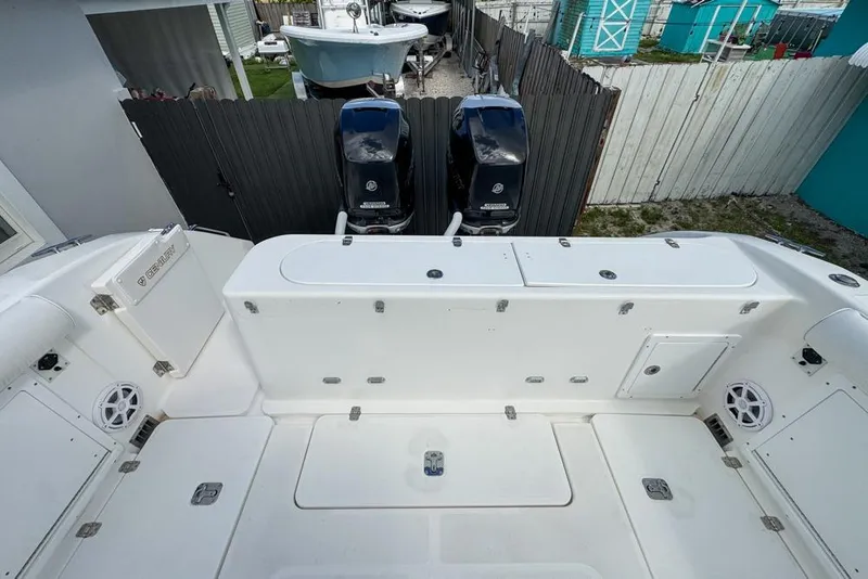 Slide: The Image of 2000 Century 3200 Center Console boat with dual outboard motors, docked in a yard. - 56