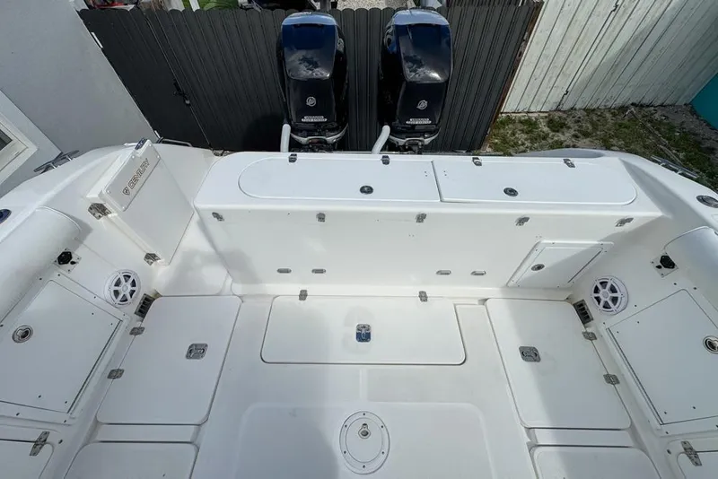 Slide: The Image of 2000 Century 3200 Center Console boat deck with storage compartments and dual outboard motors. - 58